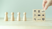 Wooden blocks and figurines depicting the various aspects of an employee benefits package