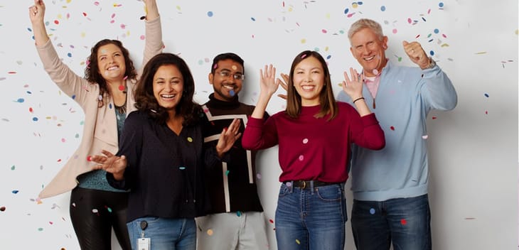 ServiceNow team members throwing confetti in the air